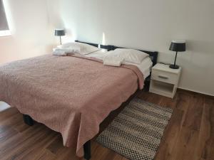 ein Schlafzimmer mit einem Bett mit einer braunen Decke und einem Teppich in der Unterkunft Apartman Lena in Zadar