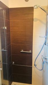y baño con ducha y pared de madera. en Domek Leśny Reset, en Studzienice