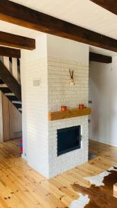 a living room with a white brick fireplace at Domek Leśny Reset in Studzienice
