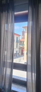 een raam met gordijnen en uitzicht op de stad bij Appartamento Montibò in Villanova dʼAsti