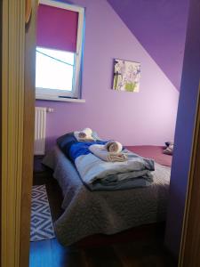 um quarto com paredes roxas e uma cama com toalhas em Apartament Charzykowy em Charzykowy