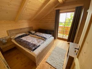 um quarto com uma cama num chalé de madeira em Chalet Montana Royal XL Koralpe em Hartelsberg