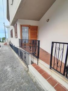a house with a black gate and a brick sidewalk at Casa Crara in Cala Gonone