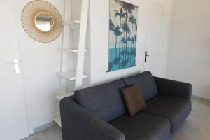 a living room with a blue couch and a mirror at Charming T2 Eden Park with swimming pool private parking in Juan-les-Pins