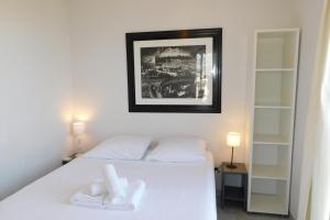 a bedroom with a bed with two white towels on it at Charming T2 Eden Park with swimming pool private parking in Juan-les-Pins
