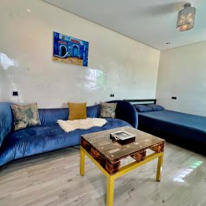 uma sala de estar com um sofá azul e uma mesa em Cozy luxurious studio with high end amenities em Fez
