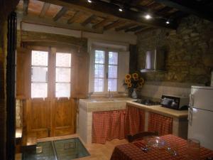 uma cozinha com um lavatório, um fogão e um frigorífico em Apartment Casa Antica em Chianni