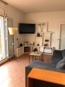 sala de estar con sofá y TV de pantalla plana en Ático en Gràcia, en Barcelona