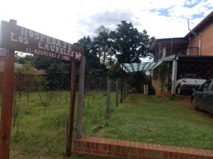 a sign in front of a fence with a yard at Hospedaje Los Laureles in Wanda
