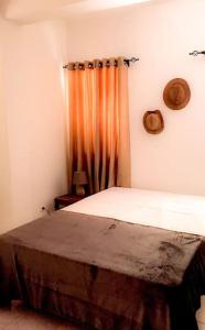 1 dormitorio con cama y cortina de color naranja en Plateau Paradise, en Praia