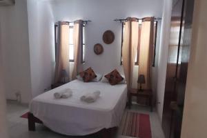Un dormitorio con una cama blanca con toallas. en Plateau Paradise, en Praia