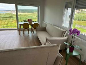 a living room with a couch and a table with chairs at Mar de Queiruga: 01 As Seiras in Porto do Son +21 photos