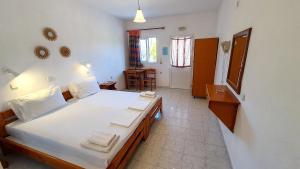 a bedroom with a large bed with white sheets at George Studios Pefkos in Pefki