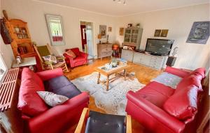 a living room with red couches and a tv at Gorgeous Home In Strmsund With Kitchen in Nedre Lillviken