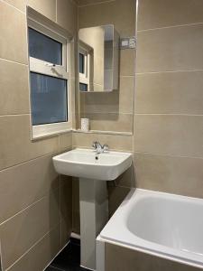 bagno con lavandino, vasca e specchio di Kemptown Courtyard Apartment a Brighton & Hove