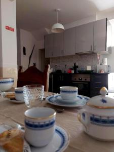 a kitchen with a table with bowls and plates on it at Casa da Palmeira in Sesimbra