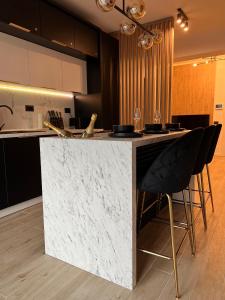 a kitchen with a counter with black and white marble at Elite Summer Suite in Năvodari