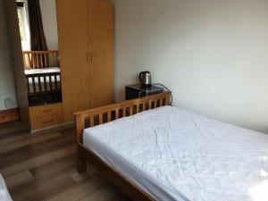 1 dormitorio con 1 cama con marco de madera en Rowland Hill House, en Londres