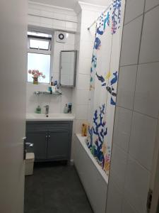 baño con lavabo y cortina de ducha en Rowland Hill House, en Londres