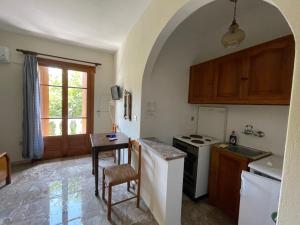 a kitchen with a table and a stove top oven at Villa Apostolis Studios in Skopelos Town