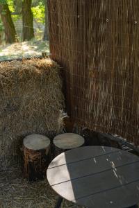 a table and three stump stools in front of a fence at MAZANKA ecocamping in Soshnikov