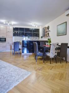 a kitchen and dining room with a table and chairs at Apartment Sahala in Tivat