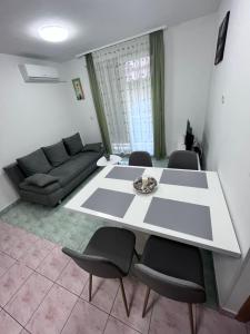 sala de estar con mesa, sillas y sofá en Apartman Josip, en Solin