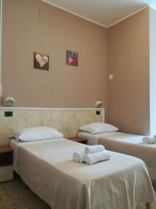 una camera con due letti con asciugamani di Hotel Villa Mon Reve a Rimini