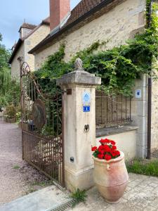 brama z doniczką kwiatów obok płotu w obiekcie Moulin Le Fleurie w mieście Charenton-du-Cher