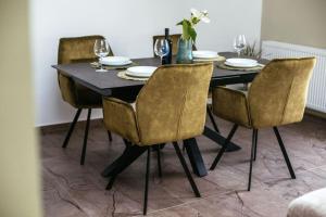 a dining room table with chairs and a black table with glasses at Holiday Home Sofia - quiet village&quick highway close to Biograd na Moru and Zadar in Benkovac