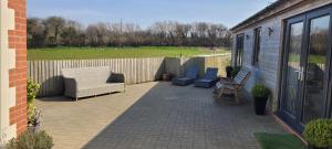 un patio con 2 sillas y un sofá en Adorable 1 bed log cabin with log burner, en Frome