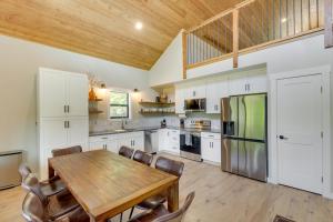 uma cozinha com uma mesa de madeira e um tecto de madeira em Beautiful Lakeside Cabin with Mountain View, Hot Tub em Lakeside