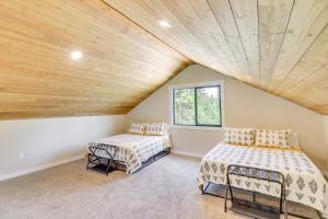 two beds in a room with a wooden ceiling at Modern Lakeside Cabin with Mountain Views and Hot Tub! in Lakeside