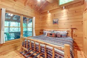 sypialnia z łóżkiem w drewnianym domku w obiekcie Ellijay Cabin with Deck and Hot Tub! w mieście Ellijay