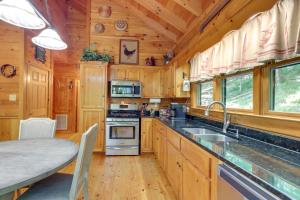 a large kitchen with wooden cabinets and a counter top at Ellijay Cabin with Deck and Hot Tub! in Ellijay