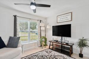 sala de estar con sofá y TV de pantalla plana en Port Charlotte Home with Sunroom, Grill and Fire Pit!, en Port Charlotte
