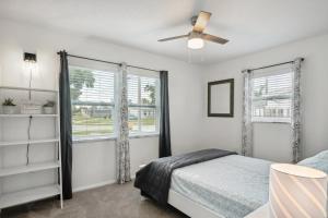 1 dormitorio con 1 cama y ventilador de techo en Port Charlotte Home with Sunroom, Grill and Fire Pit!, en Port Charlotte
