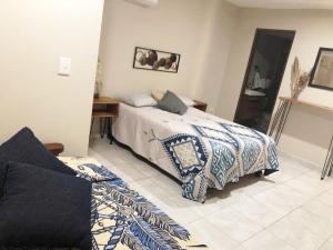 a bedroom with a bed and a table and a mirror at Casa Familiar Chocolate - Olímpica - 5 Min del Malecón in Mazatlán