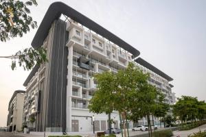 a large white building with a black roof at Blackforest 2BR Duplex at Masdar Oasis in Abu Dhabi