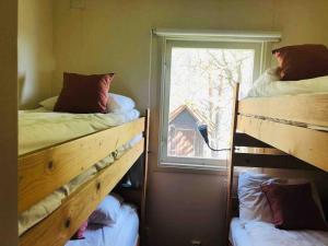 two bunk beds in a room with a window at Cottage, boat, spa, private dock, Lillesand in Lillesand