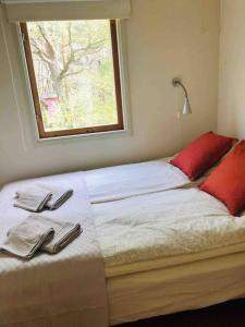 a bed with two towels and a window on it at Cottage, boat, spa, private dock, Lillesand in Lillesand