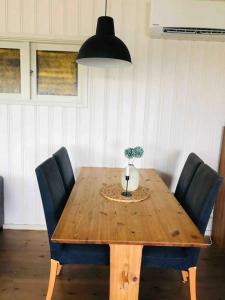uma mesa de madeira com cadeiras e um vaso com uma planta em Cottage, boat, spa, private dock, Lillesand em Lillesand