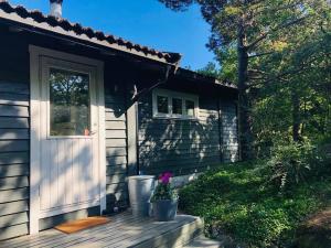 a house with a door and a potted plant on a porch at Cottage, boat, spa, private dock, Lillesand in Lillesand