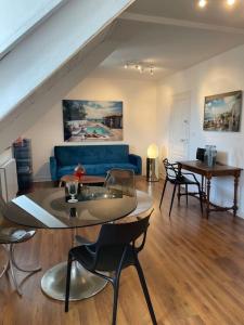 ein Wohnzimmer mit einem blauen Sofa und einem Tisch in der Unterkunft Joli appartement au cœur du village in Saint-Briac-sur-Mer