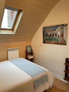 a bedroom with a bed in a room with a window at Joli appartement au cœur du village in Saint-Briac-sur-Mer