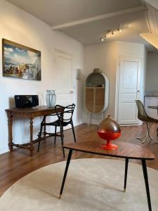 ein Wohnzimmer mit einem Tisch und einem Schreibtisch in der Unterkunft Joli appartement au cœur du village in Saint-Briac-sur-Mer