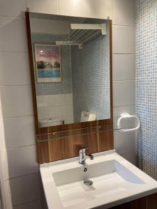 ein Bad mit einem Waschbecken und einem Spiegel in der Unterkunft Joli appartement au cœur du village in Saint-Briac-sur-Mer