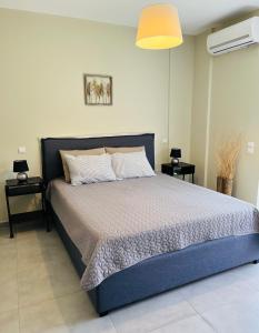 ein Schlafzimmer mit einem blauen Bett und zwei Nachttischen in der Unterkunft Zonapartments B sea view- city center in Chania