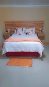 Standerton的住宿－The Success Guest House，一间卧室配有一张带2个床头柜的大床