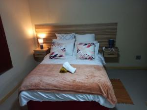una camera da letto con un letto e un asciugamano sopra di The Success Guest House a Standerton